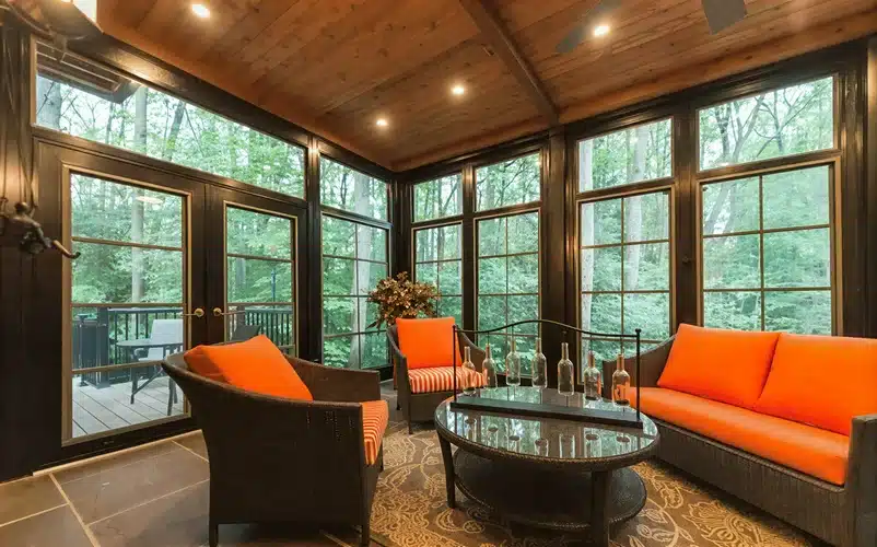 Porch conversions featuring wood-paneled ceilings, floor-to-ceiling glass, and rustic exteriors.