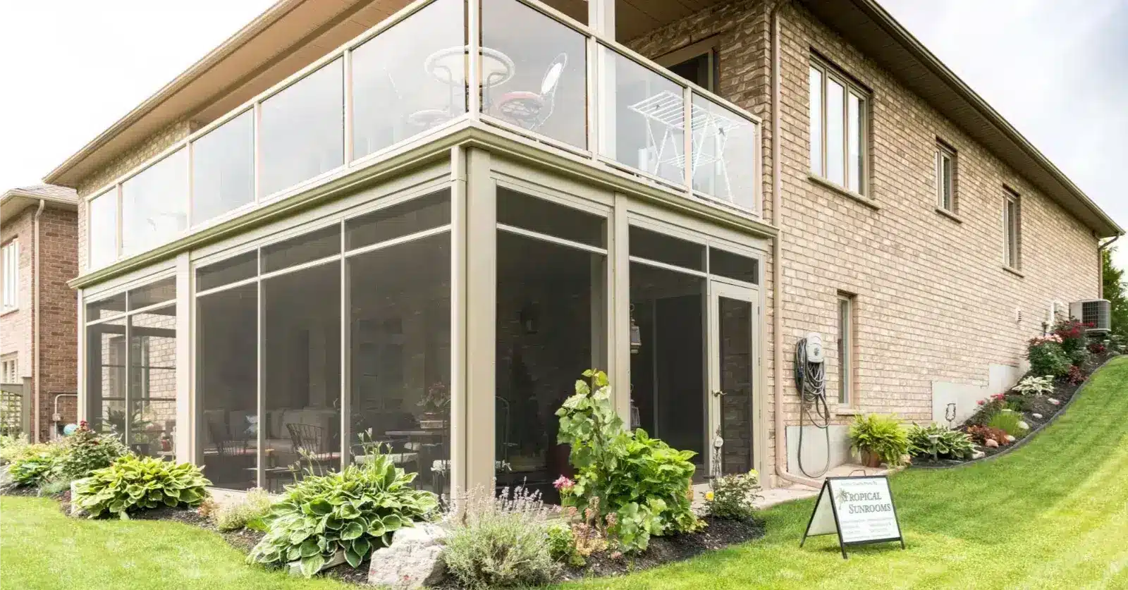 Sunspace Sunrooms Model 100 with a screened-in lower enclosure and glass railing balcony above.